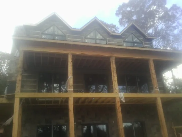 Dormers and porch framing on a large log home under construction — Roof Coating work by our crew in Margate City